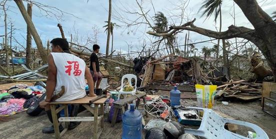 Una familia rescata sus pertenencias de su casa destruida en la isla de Siargao. Foto: Richard Dy/Plan International